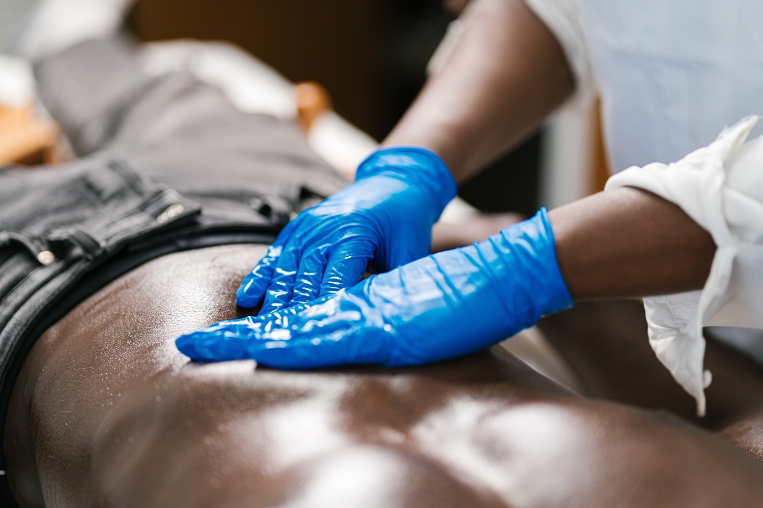 Massage therapy session with gloved hands.