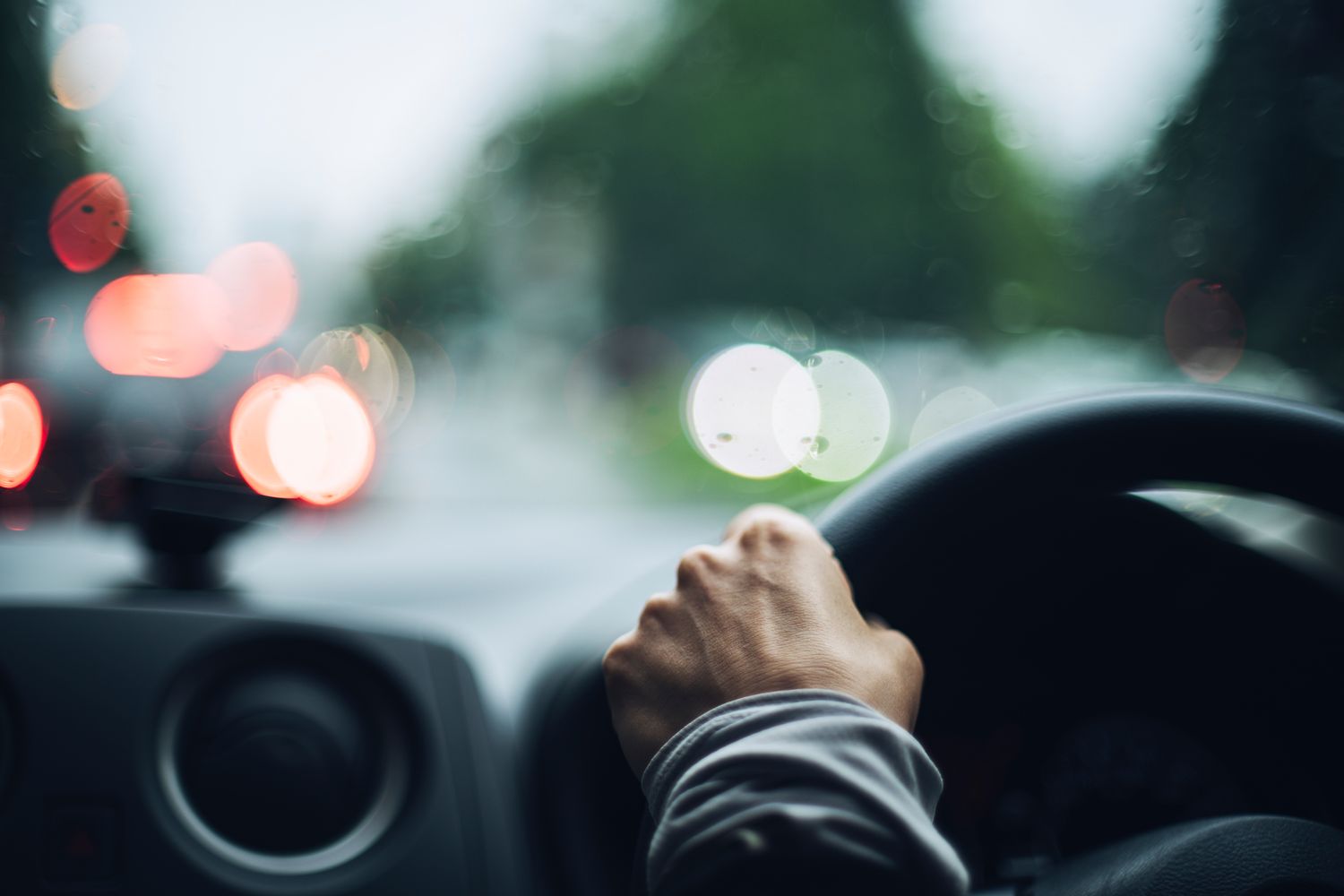 Person driving a car in rainy weather.