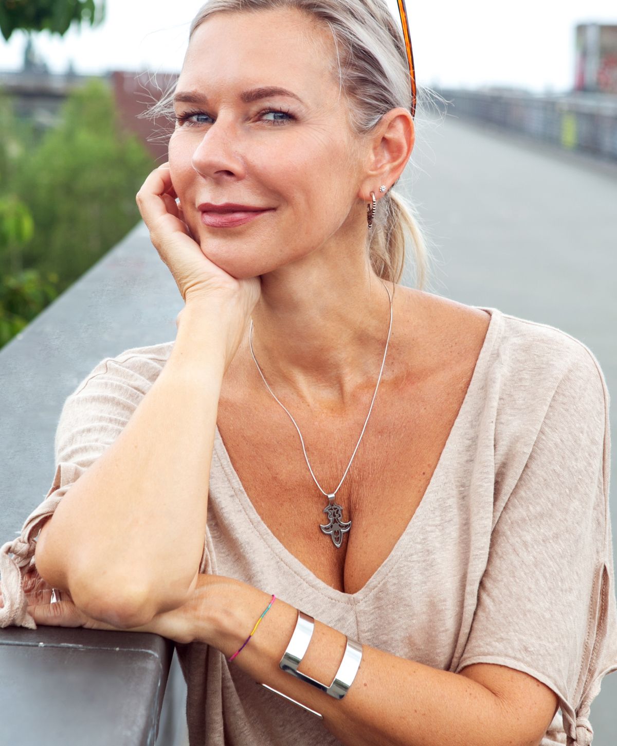 Smiling woman resting chin on hand outdoors.