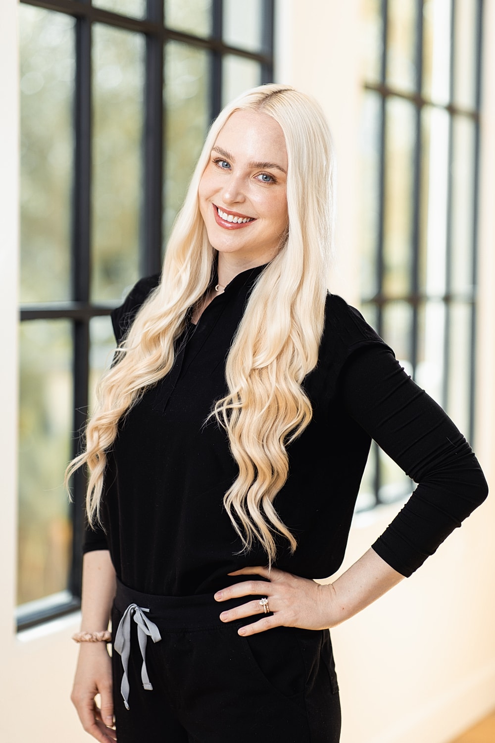 Smiling woman with long blonde hair indoors.