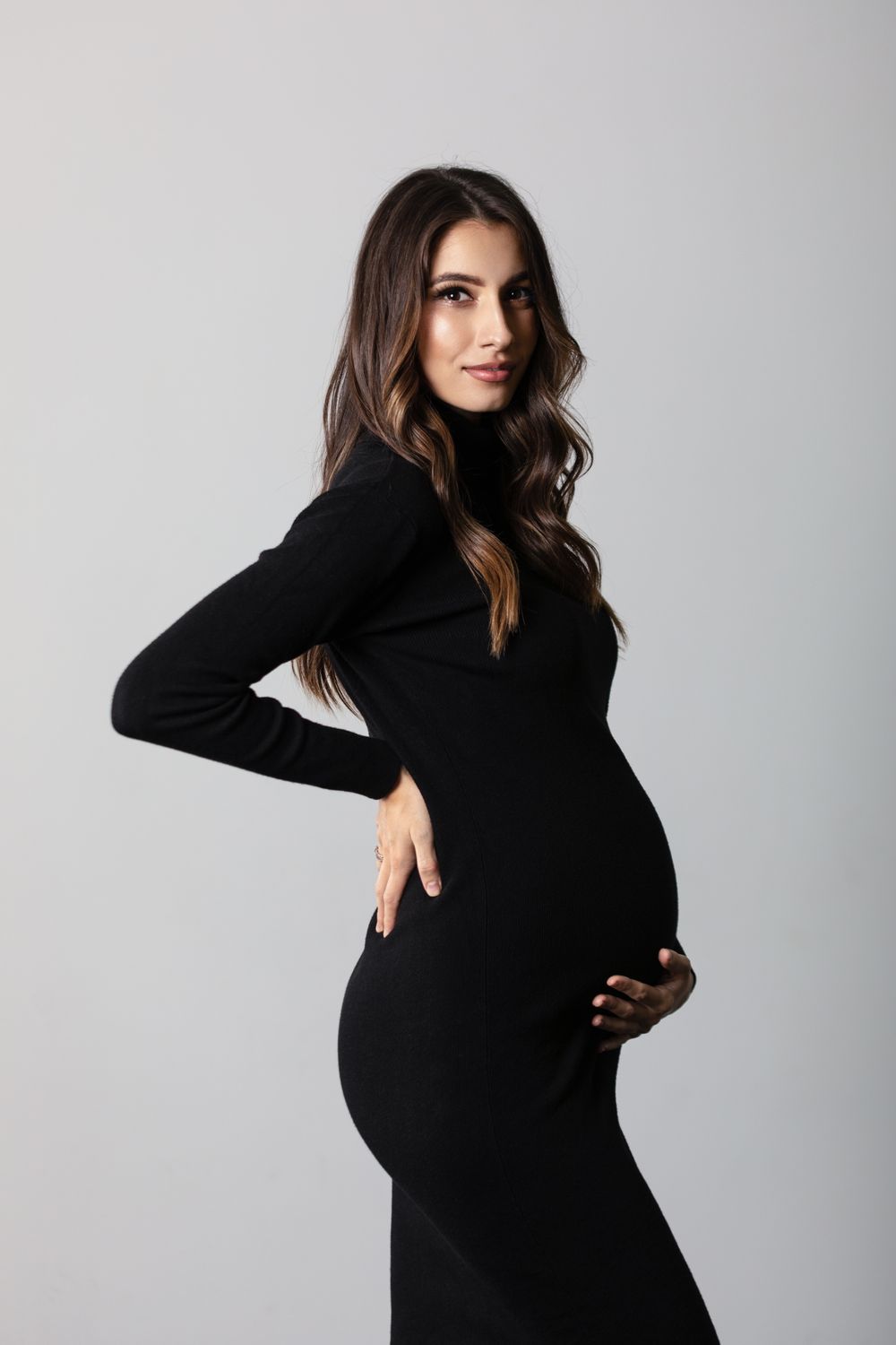 Woman looking in mirror, adjusting her hair.