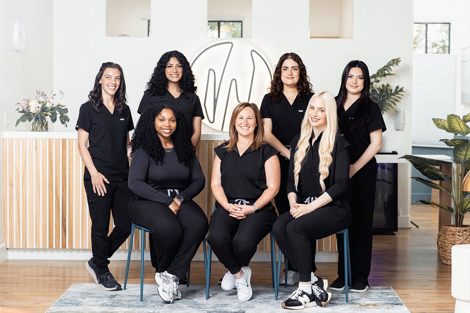 Group of women in professional attire posing together.