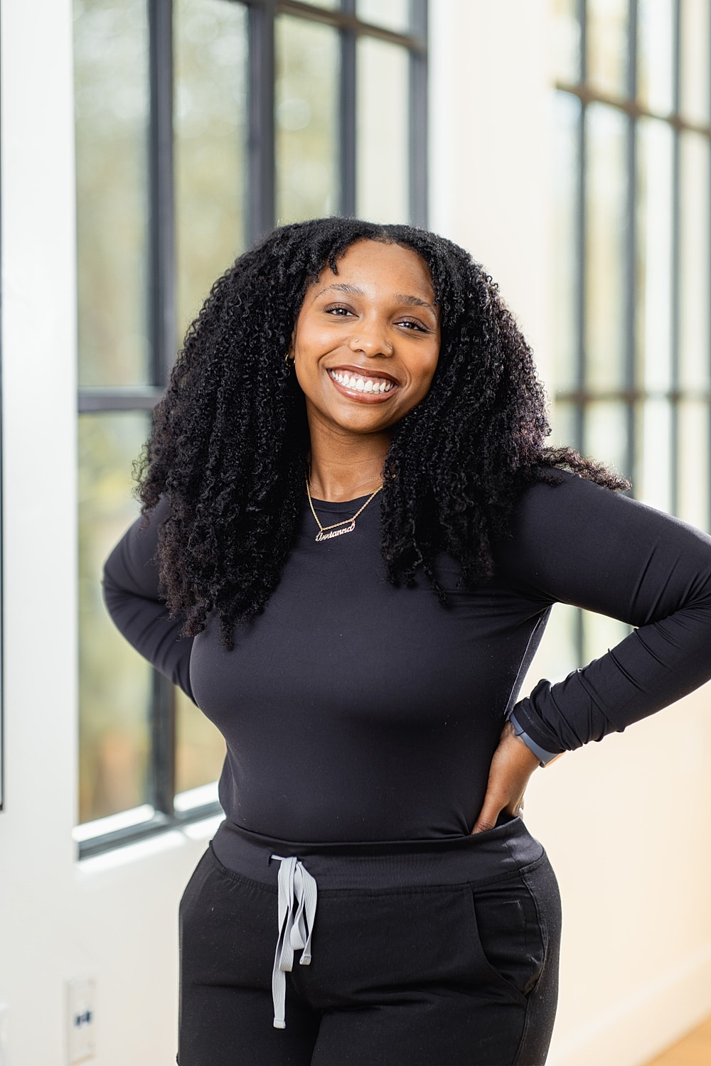 Smiling woman with curly hair in casual attire.