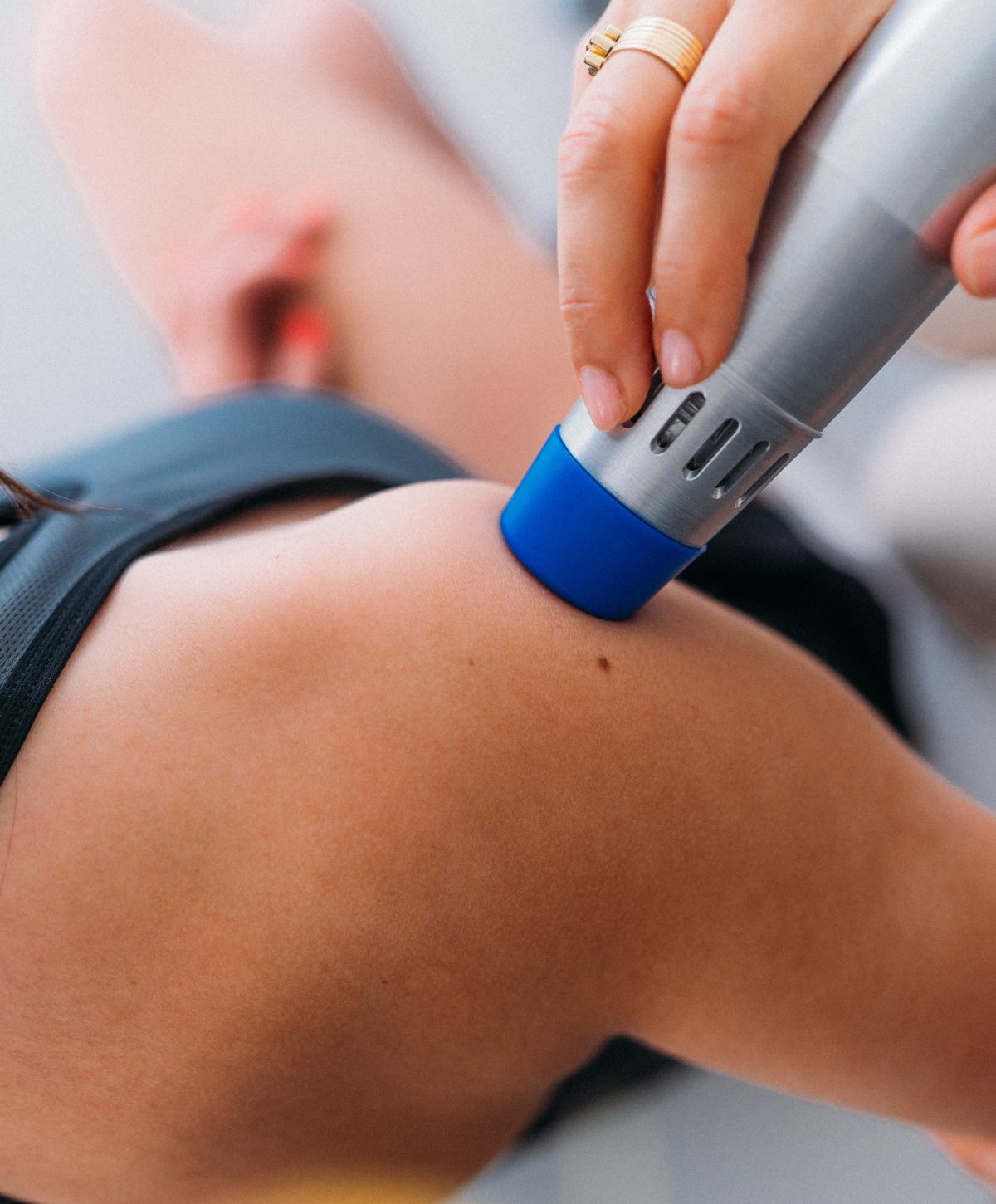 Hand using a massage device on shoulder.