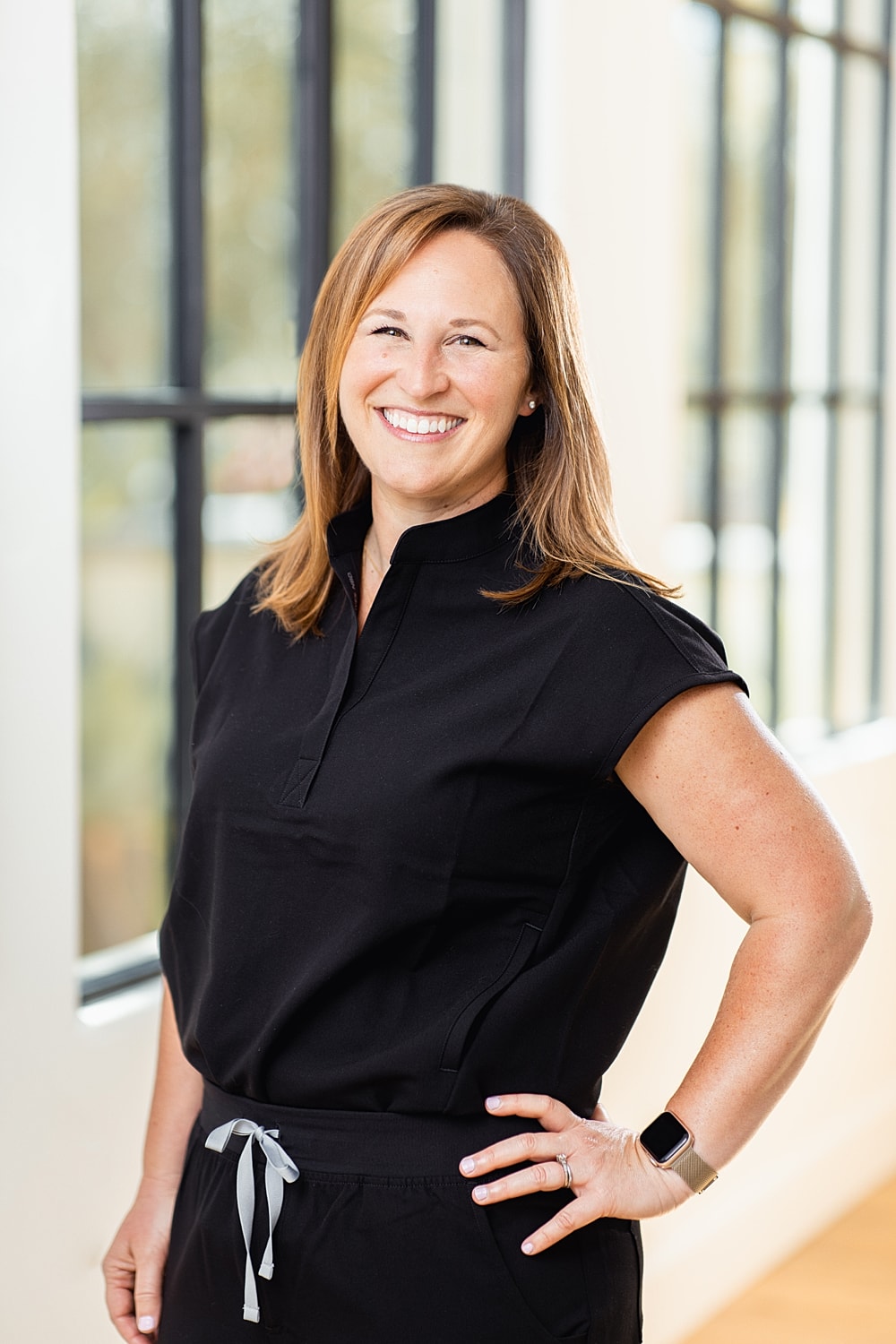 Smiling woman in black outfit indoors.