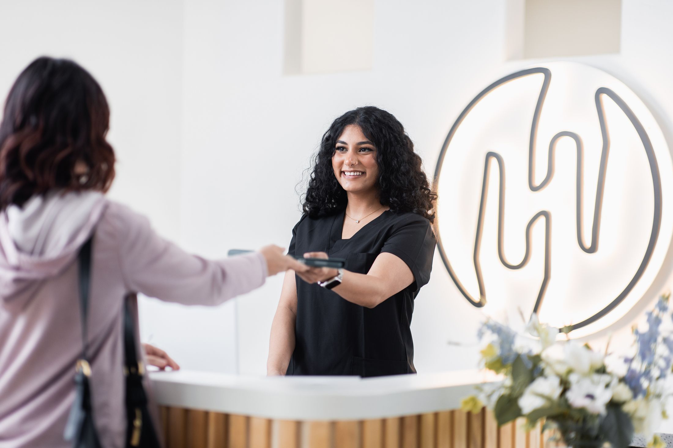 Receptionist assisting a customer at the front desk.
