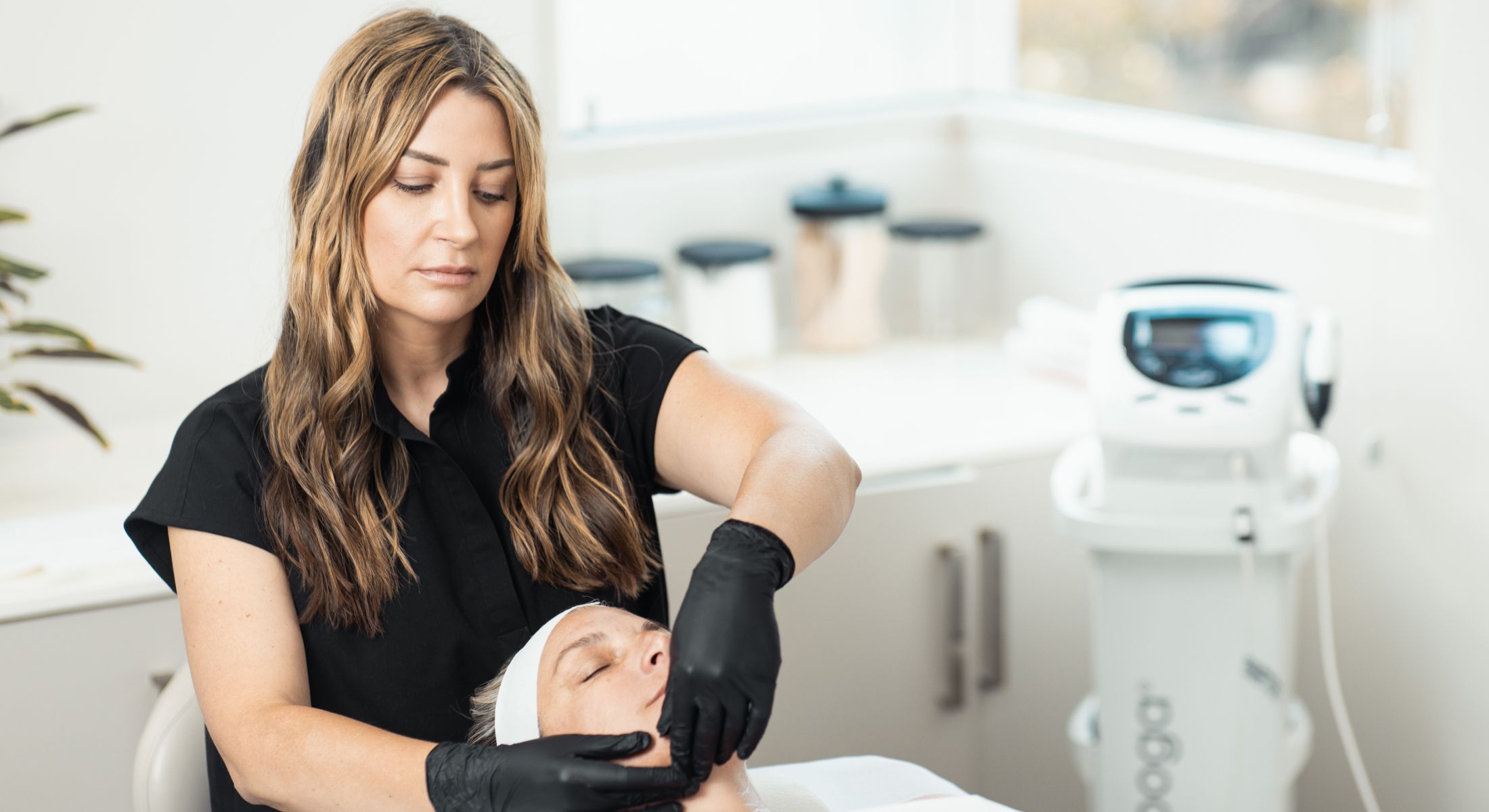 Esthetician performing a facial treatment on client.
