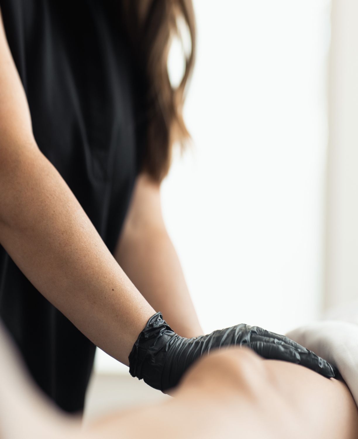 Massage therapy hands with black gloves